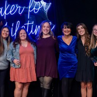 Group of 5 girls and President Mantella stand in front of Laker for a Lifetime neon sign